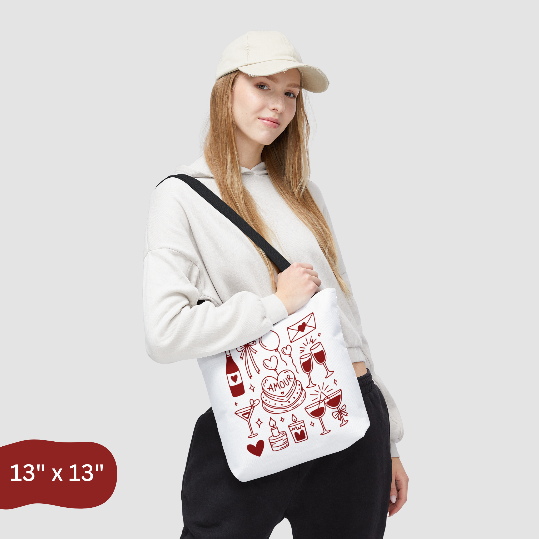 Person holding a white tote bag with red graphics on a light gray background